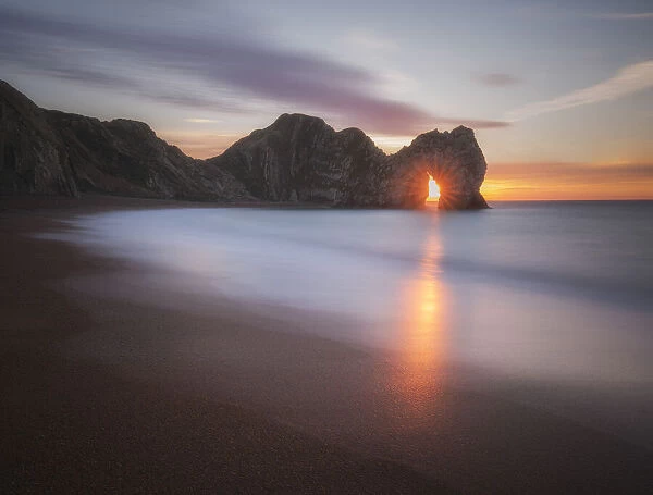 Sunrise through Durdle Door, Jurassic Coast, Dorset, England, UK