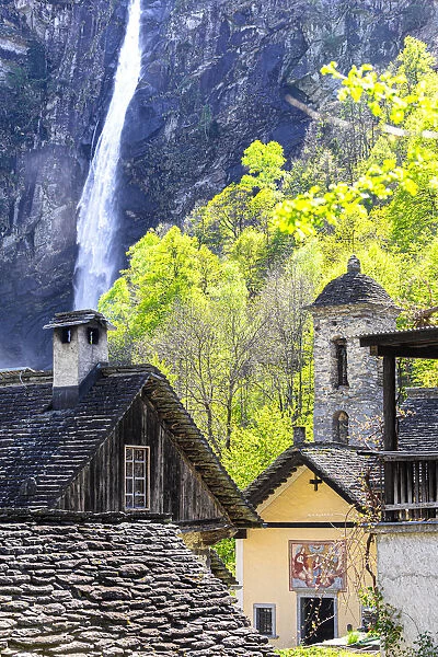 Traditional houses and church of Foroglio with the waterfall in the background, Val