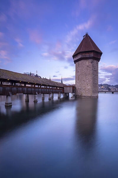 View of the Kapellbrucke bridge and the Wasserturm at sunset reflected on the Reuss river. Lucerne, canton of Lucerne, Switzerland