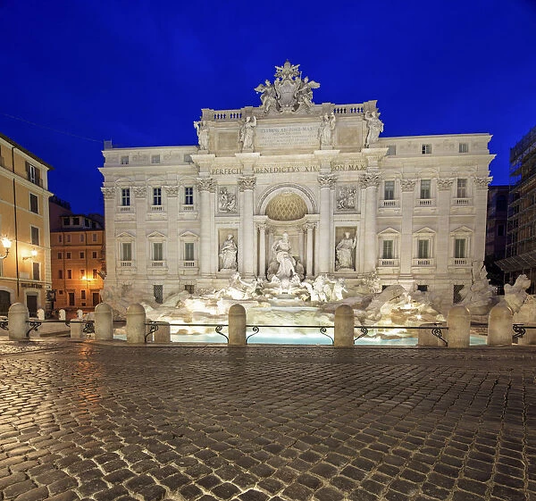 View of Trevi Fountain illuminated by street lamps and the lights of dusk Rome Lazio