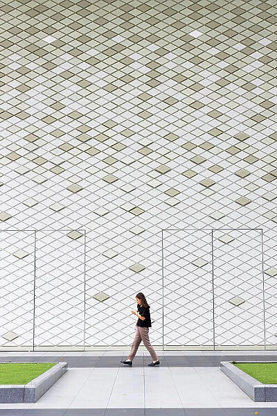 Woman walking past Breeze Xinyi shopping mall, Xinyi, Taipei, Taiwan
