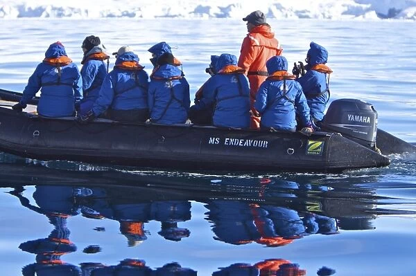 Reflected images of guests from the Lindblad Expedition ship National Geographic Endeavour on Zodiac tour around the Antarctic Peninsula in the summer months. Lindblad Expeditions pioneered Antarctic travel in 1969 and remains one of the premier