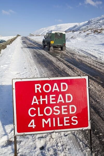 A road closed sign on top of Kirkstone Pass in the Lake District in Winter snows