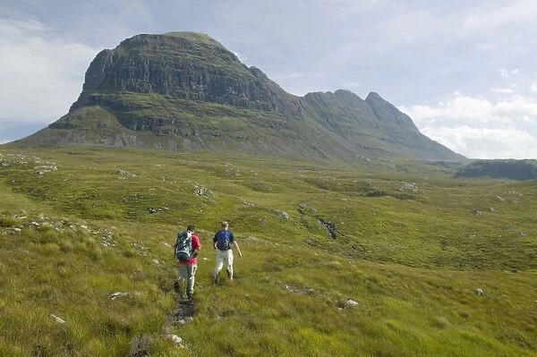 Walkers approaching Suilven mountain in Sutherland Scotland UK