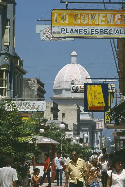 10011445. CUBA Cienfuegos Busy street scene with people hanging shop signs