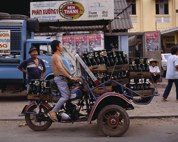 10015633. VIETNAM South Ho Chi Minh City Man riding motorbike laden with beer bottles