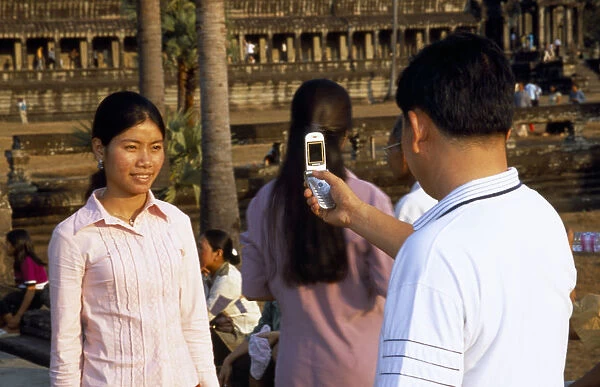 20053655. CAMBODIA Angkor Wat Man photographing a girl with his mobile phone