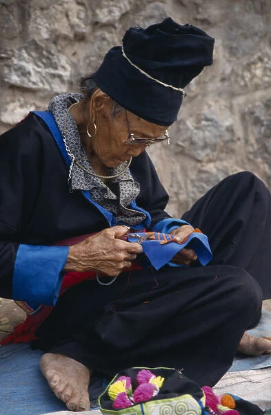 20066697. LAOS Luang Prabang Hmong woman embroidering traditional textile