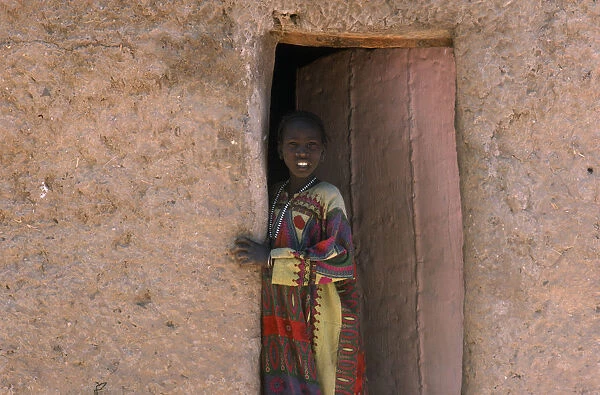 20075111. NIGER Fachi Young girl looking out of doorway of mud brick building