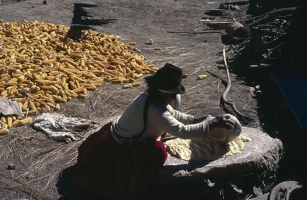 BOLIVIA, Yayani Near Cochabamba. Woman grinding maize