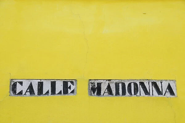 Italy, Veneto, Venice, Burano, Calle Madonna street sign on yellow wall
