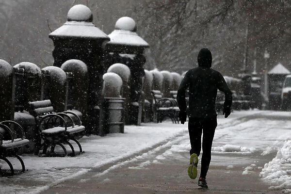 A man jogs during a snowstorm in upper Manhattan in New York City