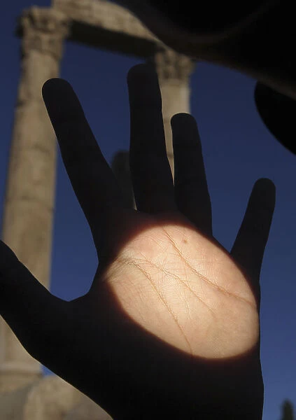 Planet Venus is seen as a black dot on a mans hand as it makes its transit across the