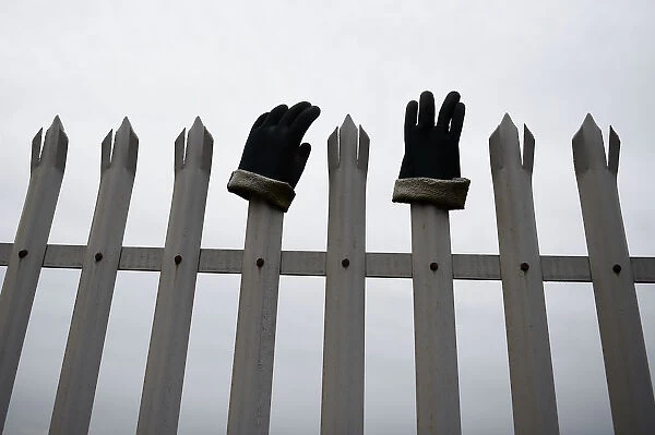 Protective work gloves are seen on railings surrounding the Bombardier plant in Belfast