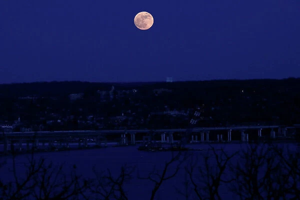 A supermoon full moon is seen above the Hudson River and the Mario M