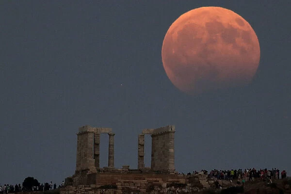 Temple of Poseidon is seen as the moon is partially covered by the Earths shadow during