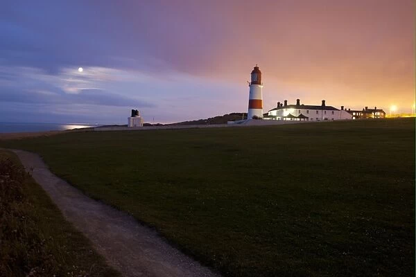 View of coastline and lighthouse at sunset, Souter Lighthouse, Marsden Bay, South Shields, County Durham, England