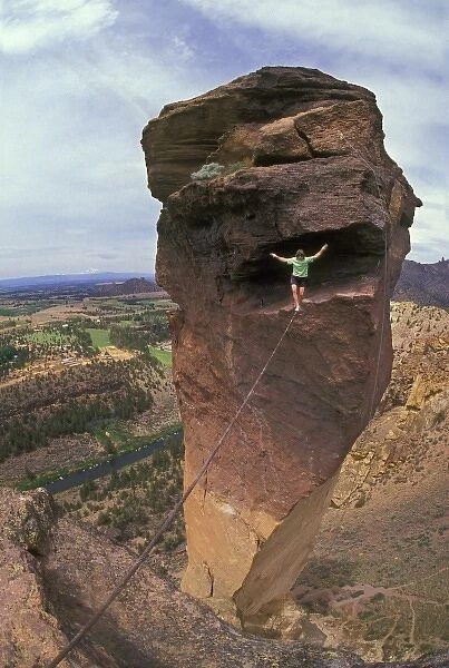 Solo rock climber walking cable stretched from free-standing Monkey Face rock to