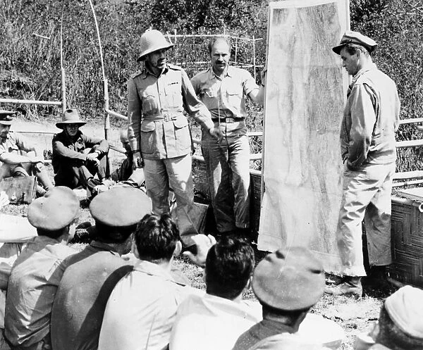 (1903-1944). British soldier. Major General Wingate, wearing pith helmet, briefing American and British officers on plans to invade Burma behind Japanese lines during World War II. At right is Colonel Philip J. Cochran, USAF, Commander of the First Air Commando Force