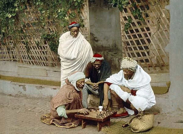 ALGIERS: CHESS GAME, c1899. Group of black Algerian men playing chess on a street in Algiers