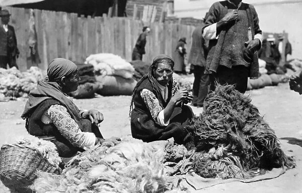 BULGARIA, c1923. Peasant woman sitting with piles of wool in a market place, Bulgaria