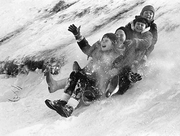 Children tobogganing down a hill in Canada. Photograph, late 20th century