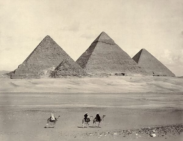 EGYPT: PYRAMIDS AT GIZA. The pyramids at Giza, Egypt, with three travelers in the foreground. Photograph, late 19th century