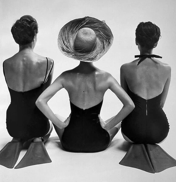 FASHION: SWIMSUITS, 1950. Back view of fashion models in swimsuits, two of them wearing swim fins