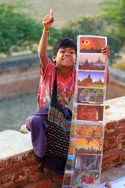 Boy selling postcards to tourists at North Guni Temple Pagoda on the Plain of Bagan