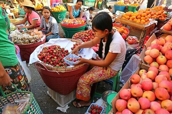 Girl selling strawberries in a street market, Yangon, Myanmar