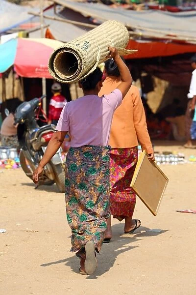 Woman carrying a carpet on her head in Old Bagan, Bagan, Myanmar (Burma)
