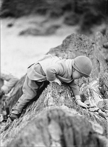 Small toddler playing on seaside rocks, Devon