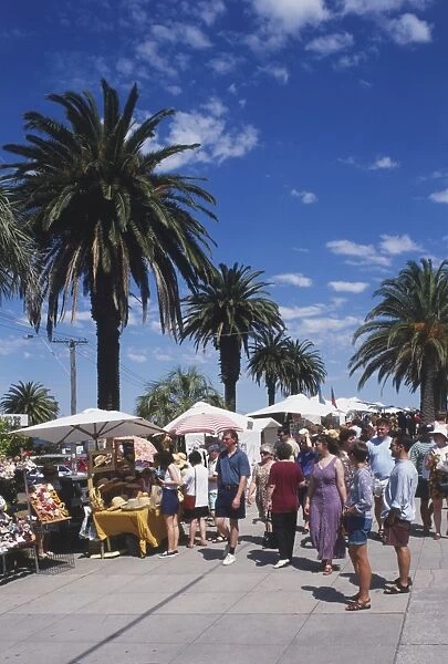 Australia, Melbourne, St Kilda Esplanade, crowds visiting crafts market on palm tree- lined boulevard