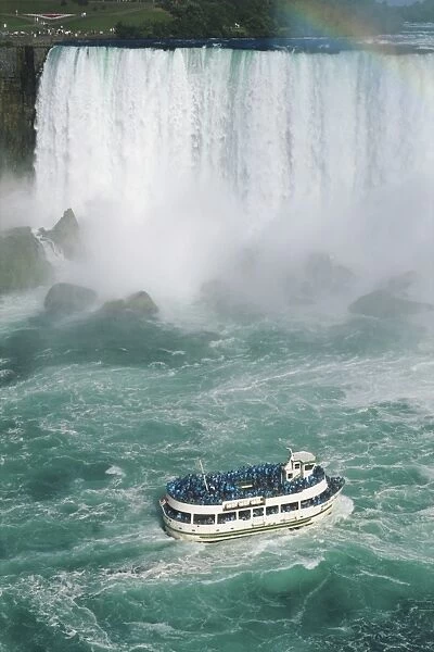 Canada, Ontario, Niagara Falls, Maid of the Mist pleasure trip in the rough water approaching Horseshoe Falls, with a rainbow visible, high angle view