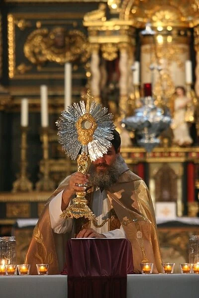 Catholic priest holding the Holy sacrament