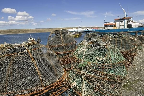 Chile, Isla Grande de Tierra del Fuego island, the Bahia Chilota ferry terminal bay port near Porvenir town, stacks of crab pots on beach