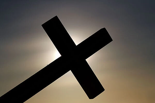 A christian cross at sunset. Concept for religion, faith, prayer and spirituality