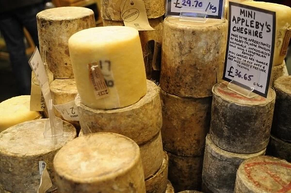 England, Blocks of whole hard cheeses on market stall