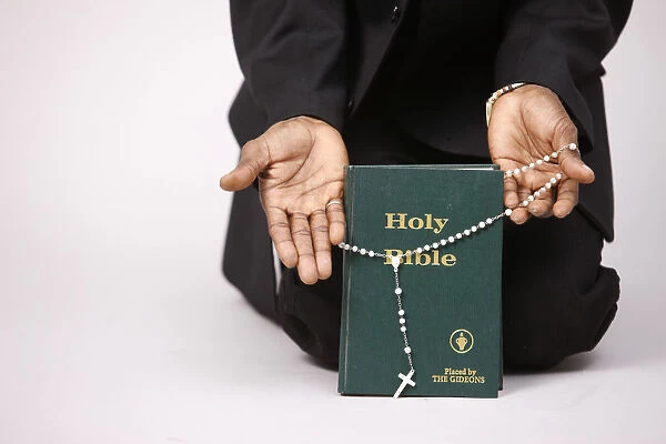 Evangelical christian holding a bible and prayer beads