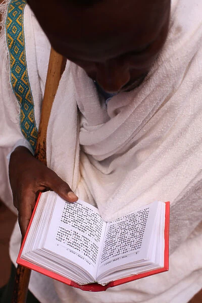 Faithful reading scriptures outside a Lalibela church