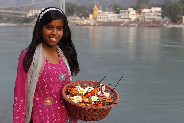Girl selling diyas (floral floats with incense) on Rishikesh ghats