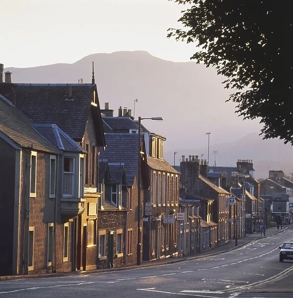 Great Britain, Scotland, Perthshire, Callander, street of terraced houses at sunset