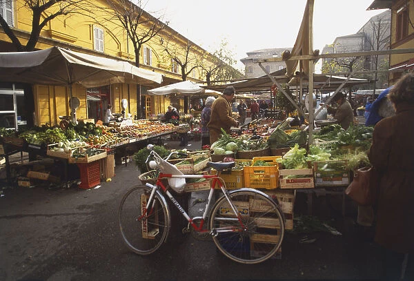 Italy, Le Marche, Frano, street lined with fruit and vegetable stalls on either side, bicycle leaning against crates at front