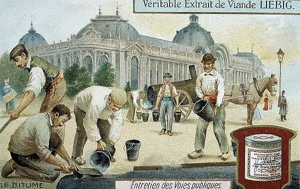 Laying bitumen road surface in a Paris street. In background man is drawing buckets