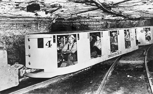 Miners in underground coal train cars