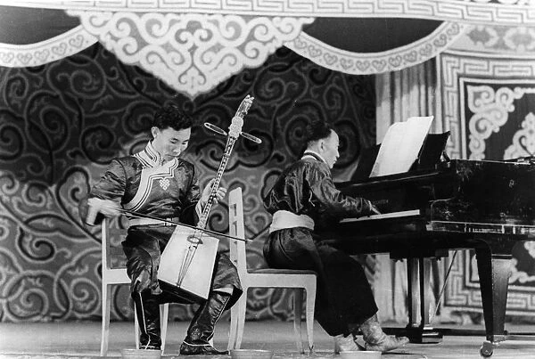 Mongolian musician dzhamyan performs a piece by schumann on a two stringed folk instrument called a marinkura (horse head fiddle), moscow, ussr, september 1947