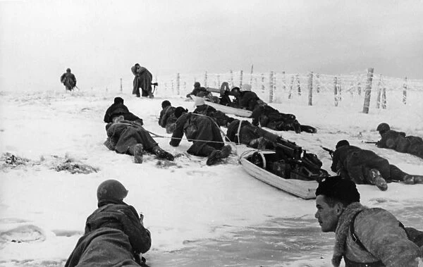 Red army troops move past frosty barbed wire dragging sleds with machine-guns on the leningrad front
