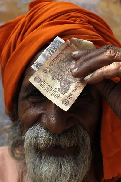 Sadhu putting alm money on his forehead