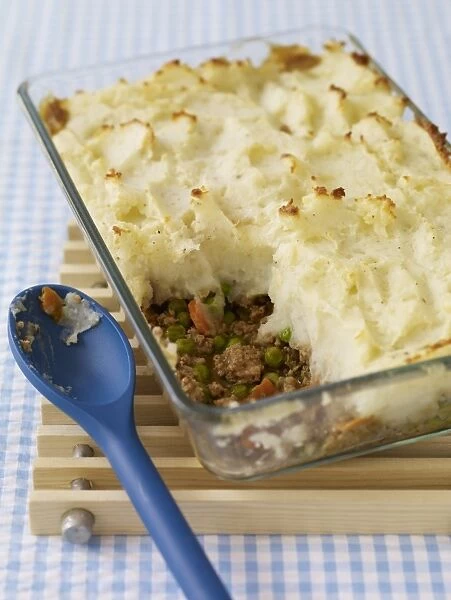 Shepherds pie in ovenproof glass dish, with spoon nearby