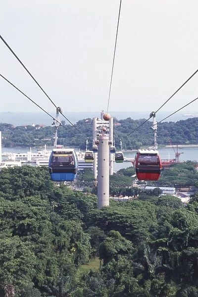 Singapore, Mount Faber, cable cars linking Mount Faber to Sentosa, blue and red cars carrying passengers in foreground, trees below, sea in background